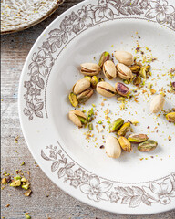 Pistachios on on light wooden base. Pistachios whole and split. 