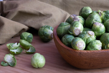 ripe Brussels sprouts lie in a wooden bowl