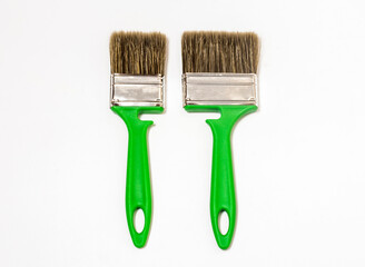 two new green construction brushes big and small on a white background