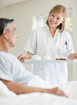 Nurse giving tray of food to patient