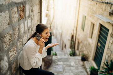 Excited laughing woman having a chat call meeting.Using a social network platform to stay connected.Smartphone app technology for internet communication.Online conversation with a friend.