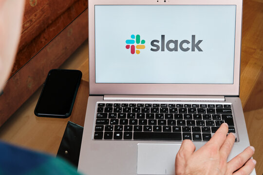 Slack is used for business meeting on laptop by man. An illustrative editorial image. San Francisco, US, June 2020