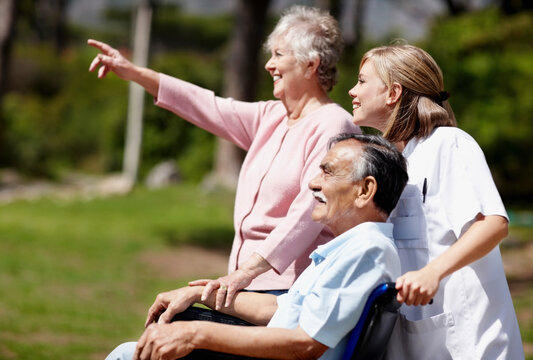 Two woman out for a walk with man in a wheelchair