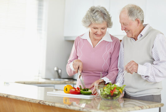 Senior couple preparing salad together
