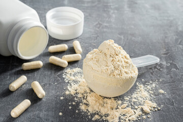 Scoop of whey or soy protein isolate, white capsules of bcaa, beta-alanine and taurine amino acids,...
