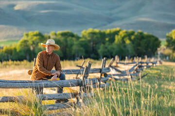 USA, Idaho, Bellevue, Rancher leaning against fence on field
