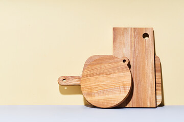 Wooden cutting boards of various shapes on bright studio background