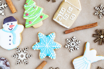 Gingerbread painted colored gingerbread cookies and spices and snowflakes on a craft background close-up. Christmas celebration concept. New Year's food.