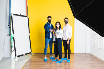 Young positive colleagues in trendy apparel and shoe covers standing with crossed arms on floor while looking at camera
