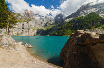 Obraz premium beautiful blue lake Oeschinensee in the Swiss Alps, with mountains in the background