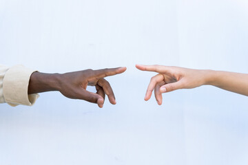 Crop unrecognizable diverse man and woman touching index fingers against white background