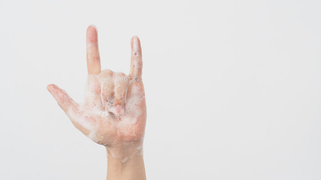 I love you or love sign, expresses tender feelings in romantic mood and romance with foam soap bubbles in hand on white background.