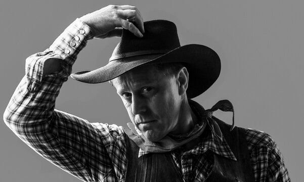 Portrait of a cowboy. West, guns. Portrait of a cowboy. Portrait of farmer or cowboy in hat. American farmer. Portrait of man wearing cowboy hat, gun. Black and white