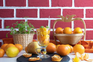a table full of fruits and stands a glass full of orange slices