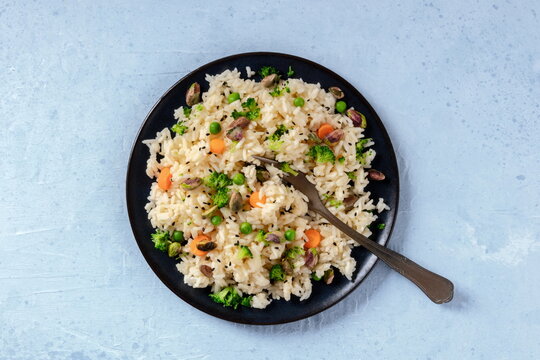 Vegan rice with carrot, broccoli and green peas, shot from the top