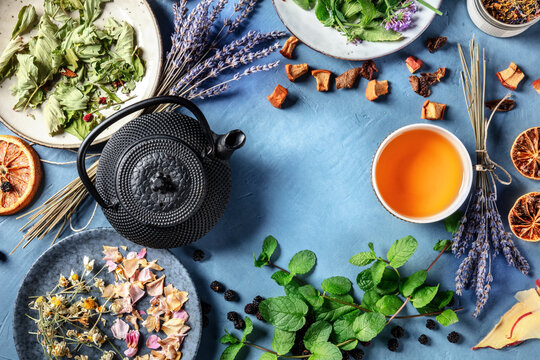 Herbal tea design template with a place for text. A frame of a tea pot, cup, and many natural, organic, and healthy ingredients, top shot