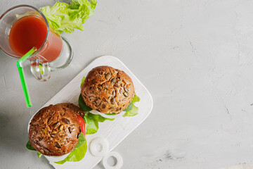 Vegetarian hamburger with tomato, lettuce, onion, bean cutlet and grain bun is an alternative to the usual hamburger. The concept of healthy eating.
