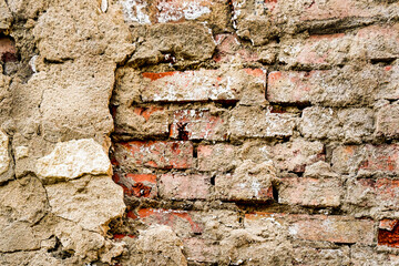 Old red brick masonry with traces of destroyed plaster.