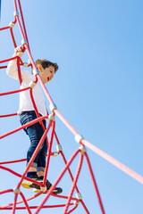 Funny boy climbing in a playground