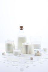 White dairy products in glass recipients on white background vertical format.