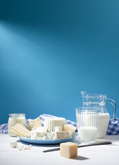 Dairy products on white wood base and blue background with  copy space. Vertical format.