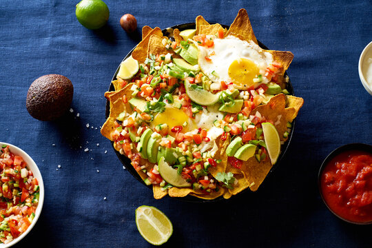 Chilaquiles mexican breakfast made of black beans, corn, tortilla chips and fried eggs