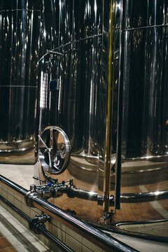 Rows of shiny stainless steel reservoirs placed in bright industrial area of modern factory