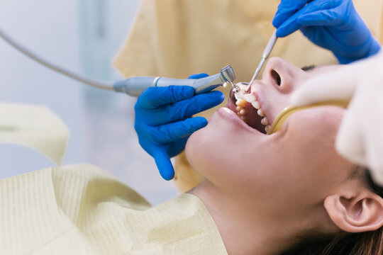 Young Female patient with open mouth examining dental inspection