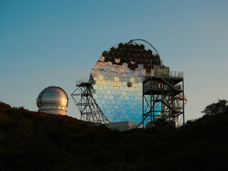 Various modern telescopes including MAGIC or Major Atmospheric Gamma Imaging Cherenkov Telescope located on hill slope at astronomical observatory on island of La Palma in Spain