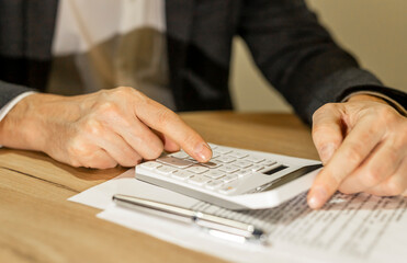 Calculating budget at office desk, close up of male hands