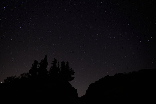 From below of dark night sky with glowing stars and Milky Way galaxy