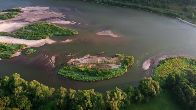 Flight through majestic foggy river Dnestr and lush green island with forest at sunrise time. Dniester canyon, Ukraine, Europe. Aerial UHD 4k drone video