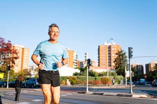 Senior retired man running through the city