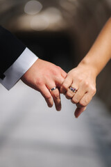 Obraz premium Hand of bride and groom hold each other. Close-up