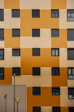 Background Of Orange Exterior Of Residential Building With Windows Of Various Sizes In City