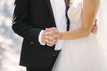 Beautiful bride with her handsome groom walking outside on theri wedding day. Happy newlyweds