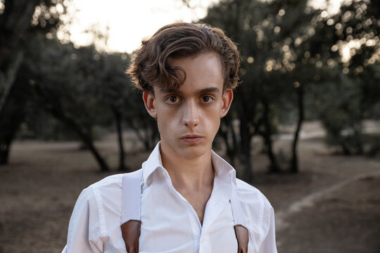 Young matador wearing suspenders standing in nature while looking at camera
