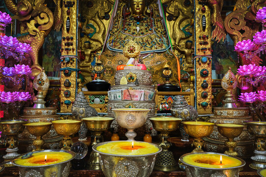 Golden decorative elements in Buddhist shrine with burning flames in praying holy place in China