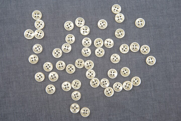 Plastic shiny buttons for clothes on a fabric background. Fashion and clothing. Factory industry