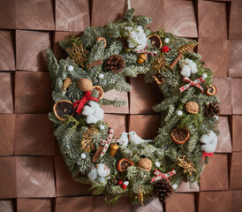 festive Christmas wreath with decorations on wall