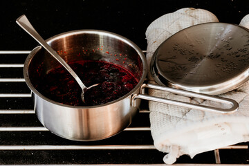 Fototapeta premium Making jam of red berries on a metal cooking pot