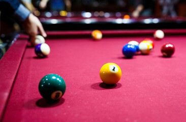 group of snooker multicolored balls lays on the table. Closeup view. Billiard red table with cue and balls. Leisure, hobby and entertainment concept