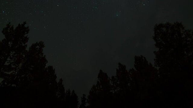 Time lapse of colorful fall foliage under starry sky into moonlit scene at Bishop Creek in Eastern Sierra Nevada mountains in California