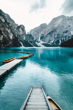 From above wooden quay on amazing scenery of lake with turquoise water in mountains on foggy day