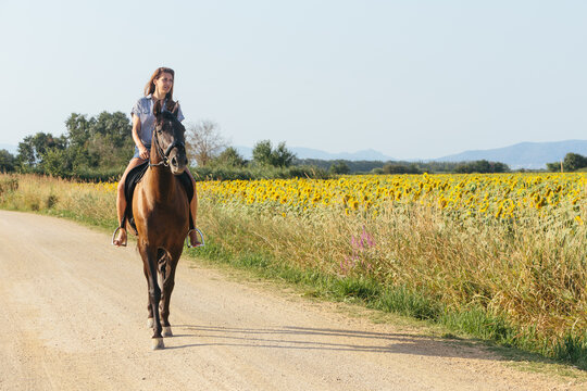 Beautiful woman riding along a country road on a sunny afternoon