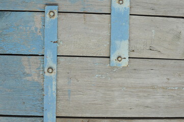 background of the old blue door with peitlami.background of blue boards with metal hinges
