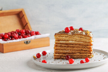 A piece of delicious honey cake decorated with cranberries. Sweet food.