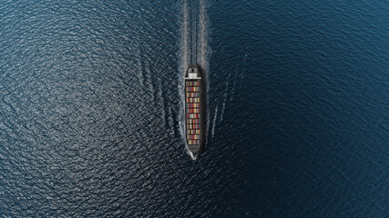 Cargo ship with containers in the open blue sea- Top down view  , Freight Shipping export and import concept, container ship carries cargo across the ocean. Transportation. Delivery. Logistics.  © ImageBank4U
