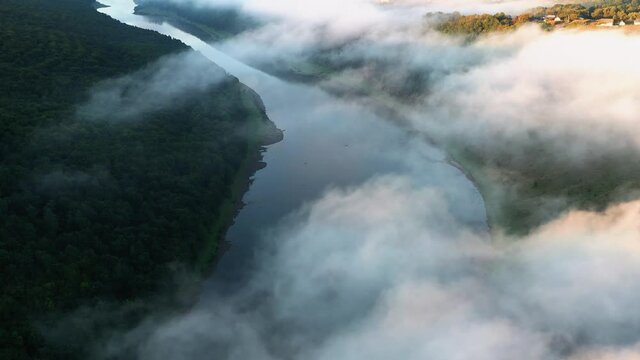 Flight through majestic foggy river Dnestr and lush green forest at sunrise time. Dniester canyon, Ukraine, Europe. Aerial UHD 4k drone video