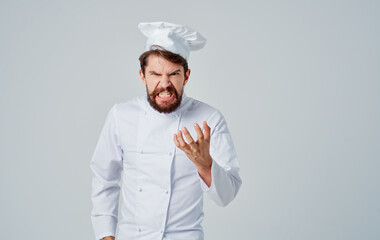 Professional chefs in uniforms are gesturing with their hands on a light background, front view